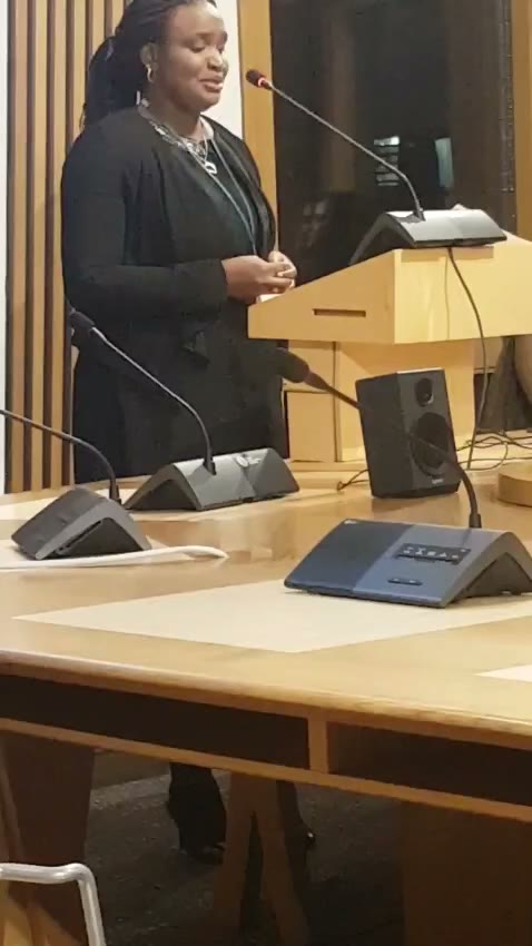 Lola at the lectern, mid-talk.